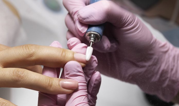 profissional-de-nail-art-trabalhando-em-unhas-de-clientes