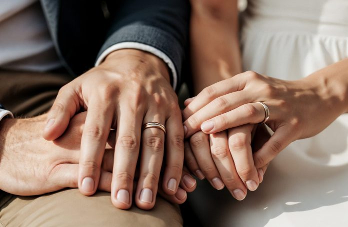 casal-de-maos-dadas-com-aneis-de-casamento