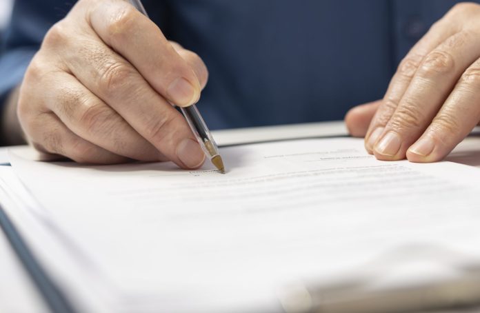 Senior man signing the financial contract with advisor expert